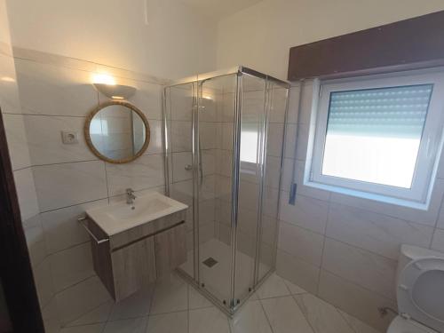 a bathroom with a shower and a sink and a mirror at Casa do Doque in Vila Nova de Foz Coa