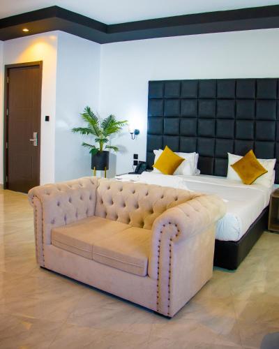 a bedroom with a large bed and a couch at Avian Court Hotel in Naivasha
