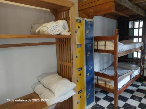 a bunk bed room with two bunk beds and a chair at Pousada e Hostel La Civetta - Maresias in São Sebastião