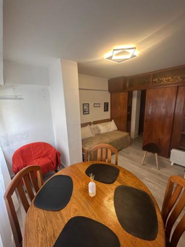 Una habitación con una mesa y un dormitorio con una cama. en Amplio monoambiente subdividido zona centro, en Pinamar