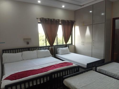 ein Schlafzimmer mit zwei Betten und einem Fenster in der Unterkunft Family Guest House in Lahore