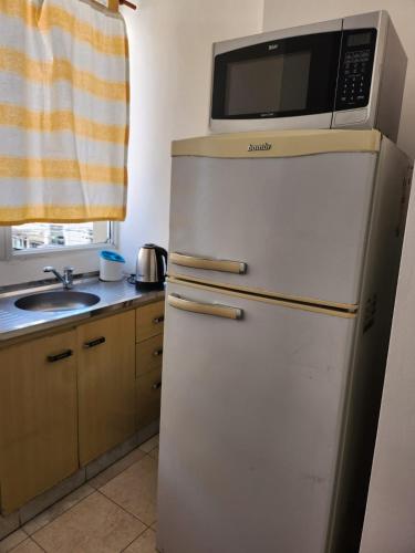 a microwave on top of a refrigerator in a kitchen at Alma Jujeña in San Salvador de Jujuy