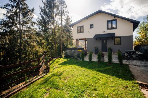 a white house with a fence and a yard at Casa Familiei Dambovicioara in Podu Dîmboviţei