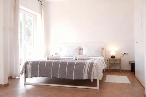 a white bedroom with a large bed and a window at Appartements Lena. in Premantura