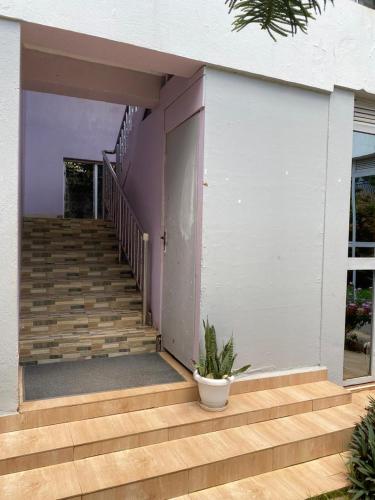 a house with a staircase with a potted plant at WELLSPRINGS HOTEl in Gulu