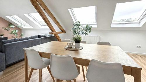 a dining room with a wooden table and skylights at Grosses Loft Apartment im Denkmal zentral in Krefeld in Krefeld