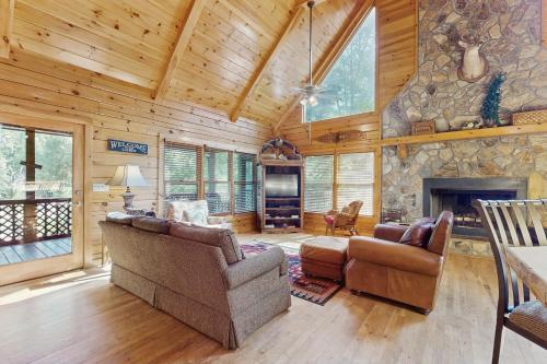 a living room with two couches and a stone fireplace at River Escape On The Toccoa in Blue Ridge