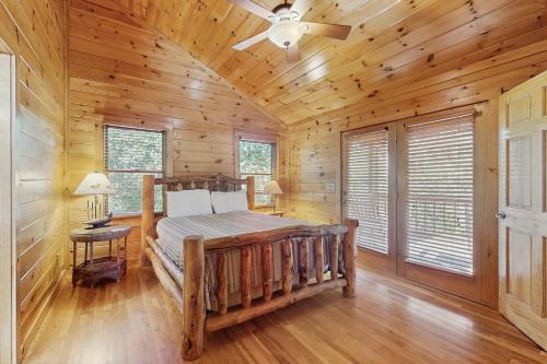 a log cabin bedroom with a bed and a ceiling fan at River Escape On The Toccoa in Blue Ridge