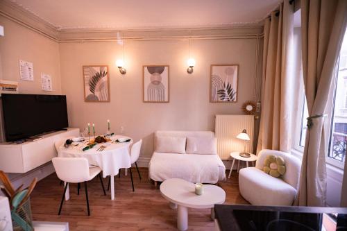 a living room with a table and chairs and a tv at Appart Centre-ville, Cathédrale, Petite France in Strasbourg