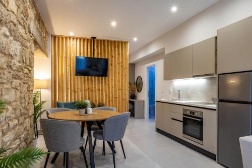 a kitchen and dining room with a table and chairs at LV Apartments Ioannina in Anatolí