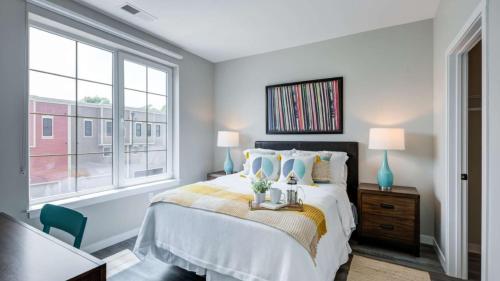 a bedroom with a bed and a large window at Modern Townhome - Walk to Yale and Downtown in New Haven