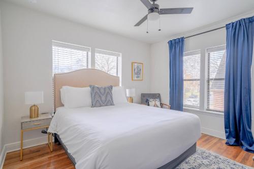 a bedroom with a large white bed and blue curtains at Spacious 6 Bed 6 Bath Duplex with a Pool in Houston