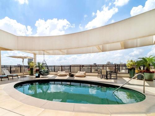 a swimming pool on the roof of a building at Grand Mercure SP Itaim Bibi in Sao Paulo