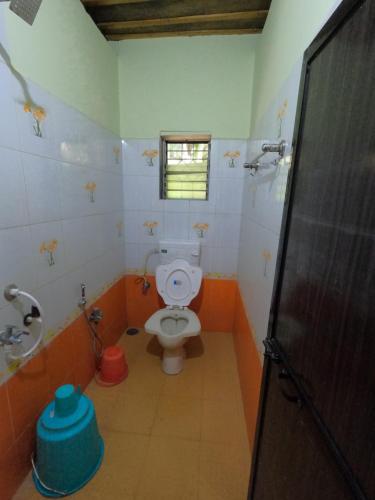 a bathroom with a toilet and a window at Travel Moody Beach touch Homestay & Campsite in Dapoli