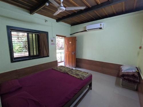 a bedroom with a purple bed in a room at Travel Moody Beach touch Homestay & Campsite in Dapoli