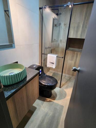 a bathroom with a toilet and a glass shower at Eureka Living in Bucaramanga