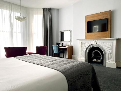 a hotel room with a bed and a fireplace at The View Hotel Folkestone, a member of Radisson Individuals in Folkestone