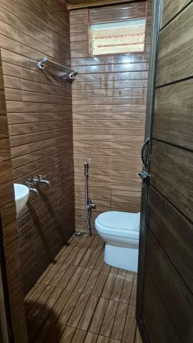 a bathroom with a toilet and a sink at Suvrana Mountain View Stay in Cherambane