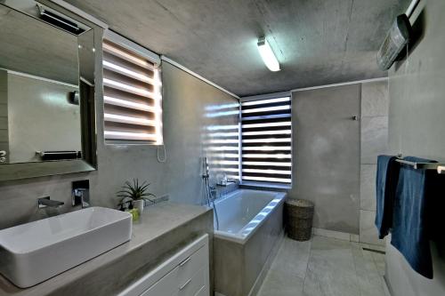 Un baño con lavabo, bañera y espejo. en At Last Glentana Apartment, en Groot Brak Rivier