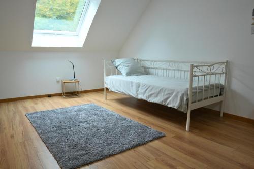 una camera con un letto con un tappeto e una finestra di Maison détente & confort près de Disney - 25 min a La Haute-Maison