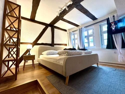 a bedroom with a bed in a room with wooden ceilings at Baumeisterhaus Suite in Bad Hersfeld