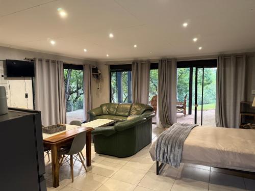 a bedroom with a bed and a couch and a table at Bushview cottage 