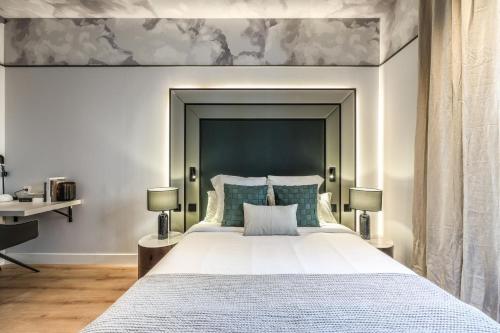 Un dormitorio con una cama grande con un cabecero grande. en Suites Madrid Centro, en Madrid