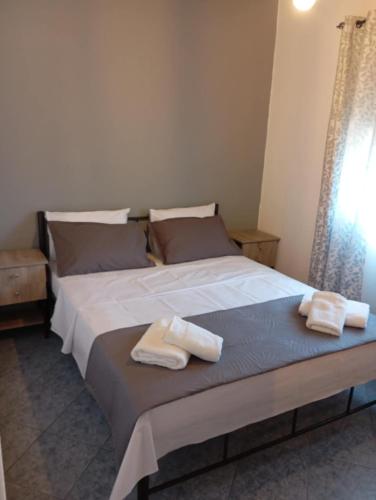 a bedroom with a large bed with towels on it at Paradise Apartment in Orfánion