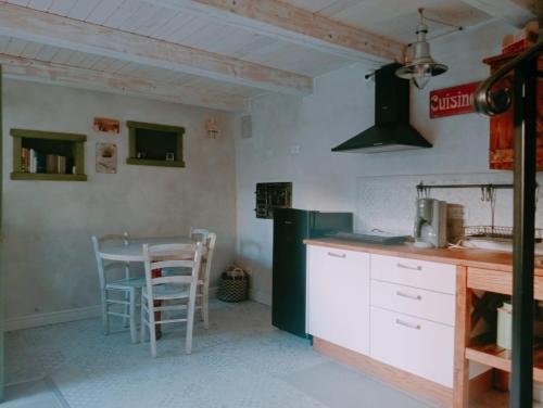 Una cocina con encimera, mesa y sillas. en Lavandula House, en Štanjel