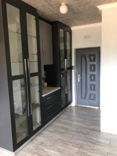 a kitchen with black cabinets and a blue door at Horizon small holding in Polokwane