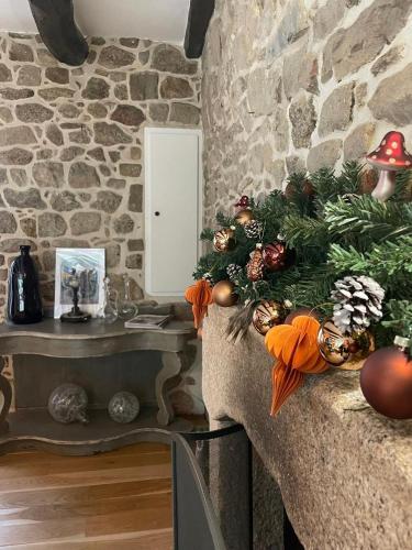 a living room with a christmas tree on a stone wall at Maison de caractère ST GOUSTAN in Auray