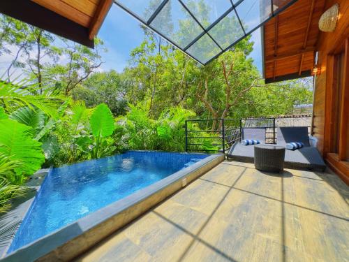 an indoor pool in a house with a glass ceiling at Palmyra Nature Resort Sigiriya in Sigiriya