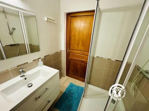 a bathroom with a sink and a shower with a mirror at Le gite turquoise in Narbonne-Plage