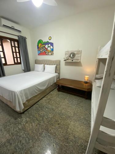 a bedroom with a bed and a ladder in it at Pousada Kembali Maresias in Maresias