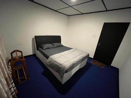 a bedroom with a bed and a blue floor at The Crowns Lodge in Nuwara Eliya