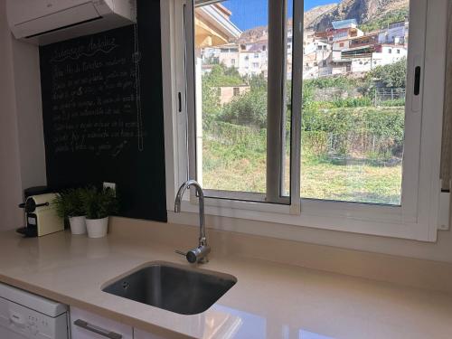 een aanrecht met een wastafel en een raam bij Nevada Suites Guejar in Güéjar-Sierra