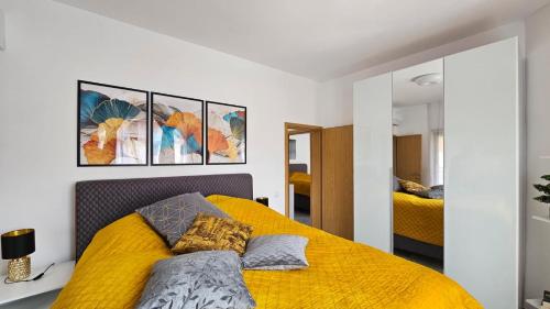 ein Schlafzimmer mit einem gelben Bett mit zwei Kissen in der Unterkunft Exklusive Villa am Sonnenstrand Bulgarien am Schwarzen Meer aheloy Cabernet 1 in Kableshkovo