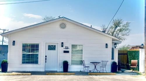 a white house with chairs and a table in front of it at Divine Casita in Del Rio