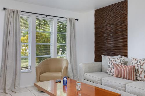 a living room with a couch and a chair and a table at Costerra Living in Naples