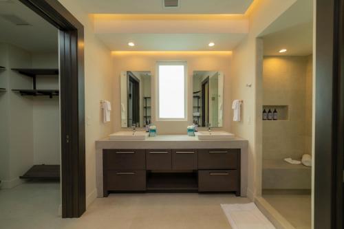 Un baño con dos lavabos y un espejo grande. en Casa Forest 4 bdrs private pool in Los Suenos, en Herradura