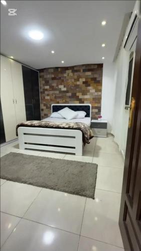 Un dormitorio con una cama y una pared de ladrillo. en KHadma vip, en Banī Ghālib