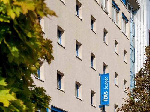 un edificio con una señal azul delante de él en ibis budget Berlin Ost, en Berlín