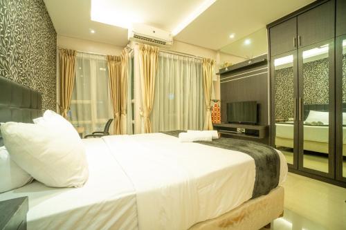 ein Schlafzimmer mit einem großen weißen Bett in einem Zimmer in der Unterkunft 1BR Near GI Mall Thamrin SCBD2 in Jakarta