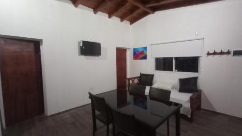 Zimmer mit einem Tisch und einem Bett sowie einem Schlafzimmer in der Unterkunft Balcones del Rio in Santa Rosa de Calamuchita