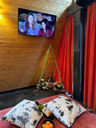 a room with two pillows and a tv on a wall at A-frame-hub in Slavske