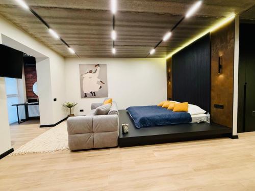 a bedroom with a bed and a couch and a chair at New Premium LOFT studio in Zhytomyr