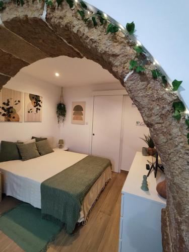 a bedroom with a bed and a tree at Templar Arch Retreat in Tomar
