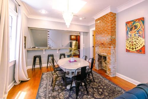 a dining room with a table and chairs and a fireplace at St. Ann Historic Creole Cottage 5 bed-4ba in New Orleans