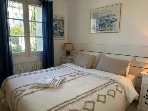 una camera da letto con un letto con una coperta bianca e una finestra di Arlore a Grimaud