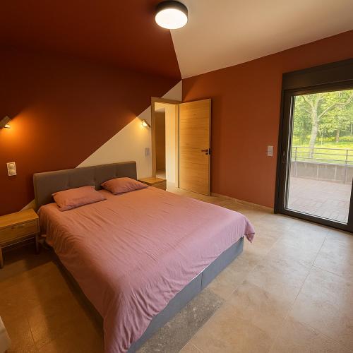 a bedroom with a large bed and a large window at L'orée du bois - Contis - Ocean and Spa in Saint-Julien-en-Born